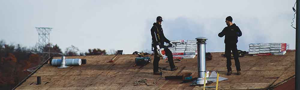 Two men doing a roof repair job.