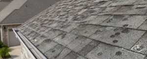 Hail damage roof Porter County Indiana home with dented asphalt shingles after a storm